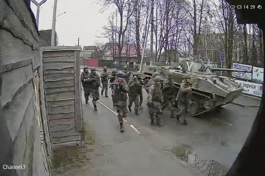 In this image from surveillance video, Russian troops take over Yablunska Street in Bucha, Ukraine on March 3, 2022, where they set up a headquarters during their month-long occupation. When Russian t ...