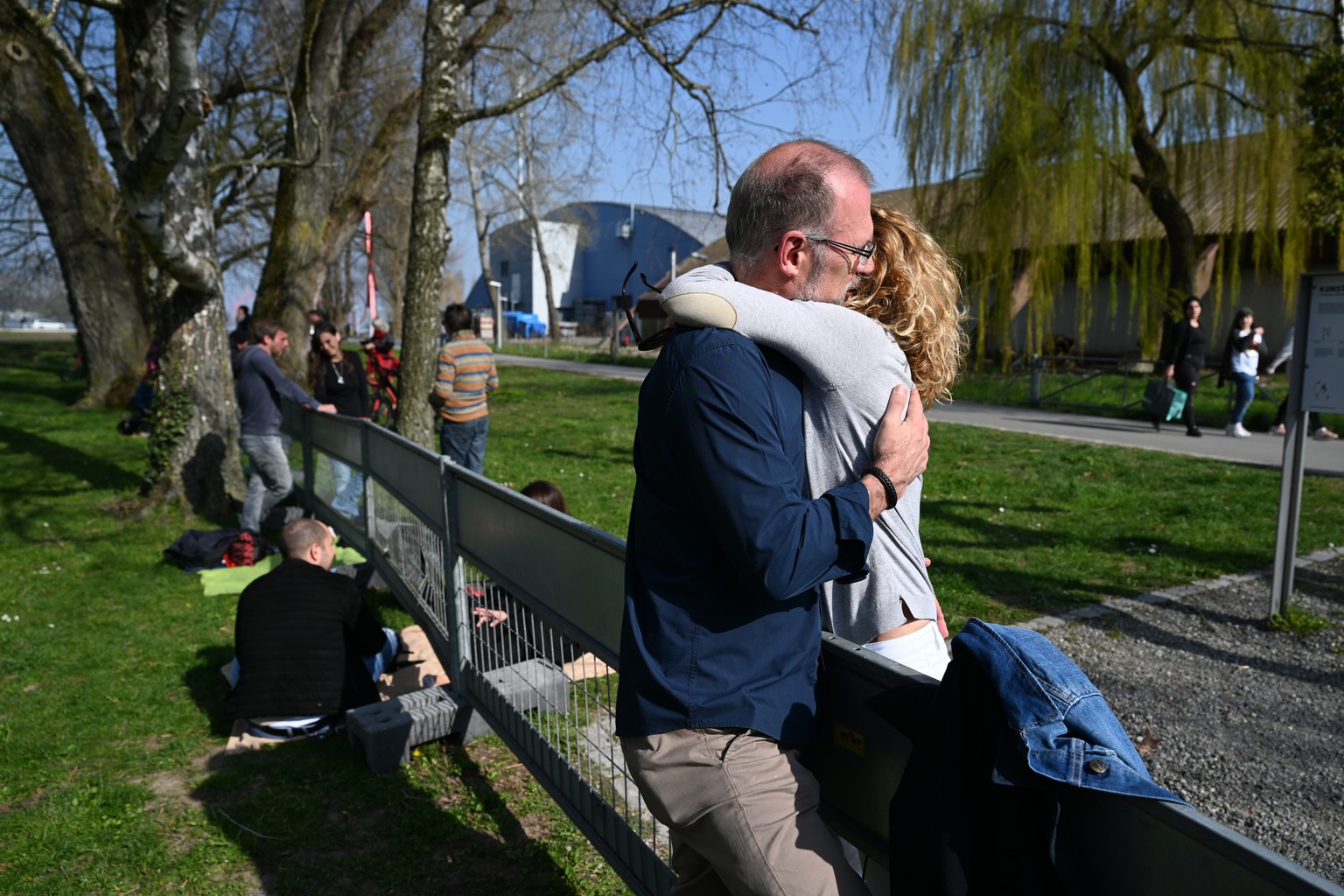 26.03.2020, Baden-Württemberg, Konstanz: Ein Paar umarmt sich an der deutsch-schweizerischen Grenze zwischen Konstanz und Kreuzlingen. Das Paar ist durch einen Grenzzaun getrennt und kann sich nur so  ...