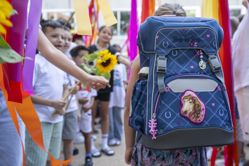 Aeltere Schuelerinnen und Schueler stehen zur Begruessung fuer eine Erstklaesslerin Spalier, zum Auftakt ins neue Schuljahr an der Primarschule Volta in Basel, am Montag, 12. August 2024. (KEYSTONE/Ge ...