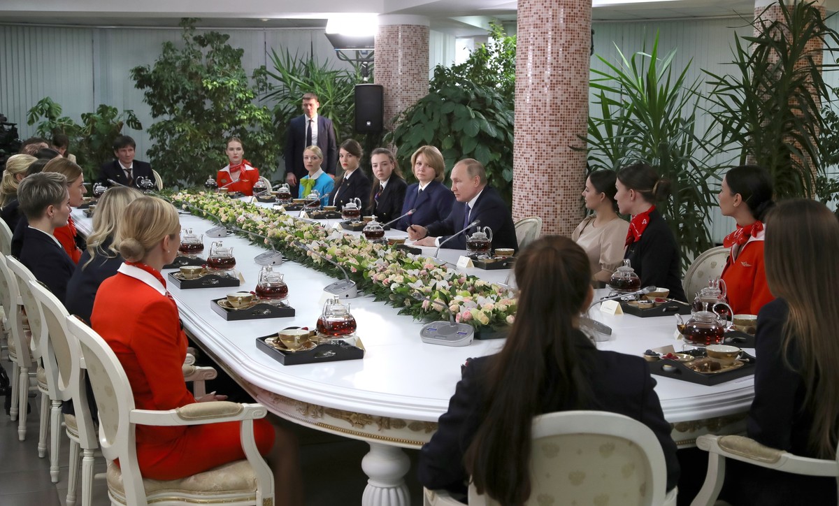 Russian President Vladimir Putin, center right, speaks to representatives of the flight crew of Russian airlines as he visits to Aeroflot Aviation School outside Moscow, Russia, Saturday, March 5, 202 ...