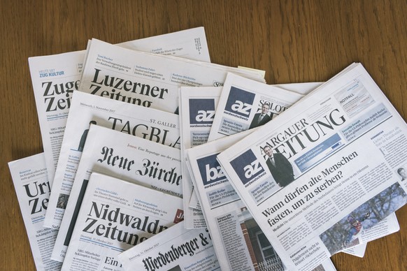 ARCHIV - ZUM ZUSAMMENSCHLUSS DER AZ MEDIEN UND DER NZZ-MEDIENGRUPPE STELLEN WIR IHNEN DIESES ARCHIVBILD ZUR VERFUEGUNG - Zeitungen der AZ Medien und der NZZ Mediengruppe liegen auf einem Tisch, am Mit ...