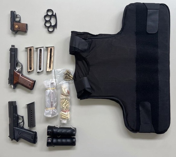Schusswaffen, Munition und eine schusssichere Weste liegen auf einem Tisch Hanfanlage ausgehoben