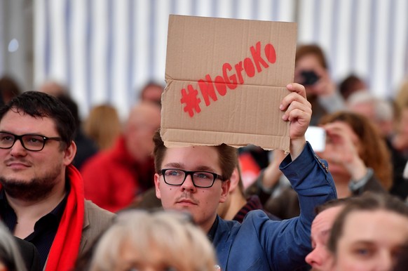 epa06523691 A visitor protests against a governing coalition of SPD and Union parties in Germany by holding a cardboard reading &#039;#NoGroKo&#039; at the Political Ash Wednesday gathering of the Soc ...