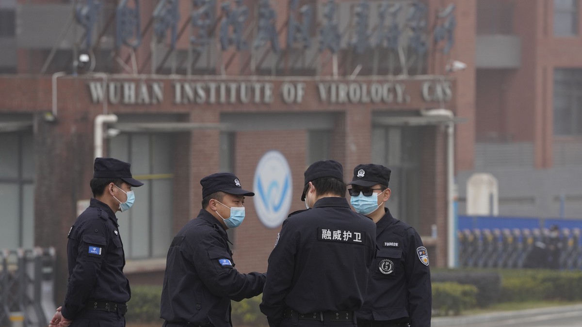 Security personnel gather near the entrance of the Wuhan Institute of Virology during a visit by the World Health Organization team in Wuhan in China's Hubei province on Wednesday, Feb. 3, 2021.  ...