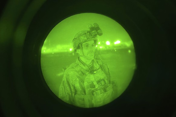 In this image made through a night vision scope and provided by the U.S. Army, Maj. Gen. Chris Donahue, commander of the U.S. Army 82nd Airborne Division, XVIII Airborne Corps, prepares to board a C-1 ...