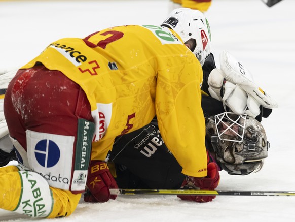 Langnaus Nolan Diem, left, and Ajoie guard Damiano Ciaccio, right, react after a fall during the National Ice Hockey League championship game between HC Ajoie and SCL Tige...