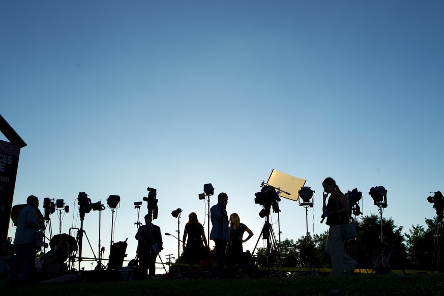 TV crews waiting for a news conference line up at the side of the road across the newspaper office building where multiple people were shot this afternoon inside of the newsroom, in Annapolis, Md., Th ...