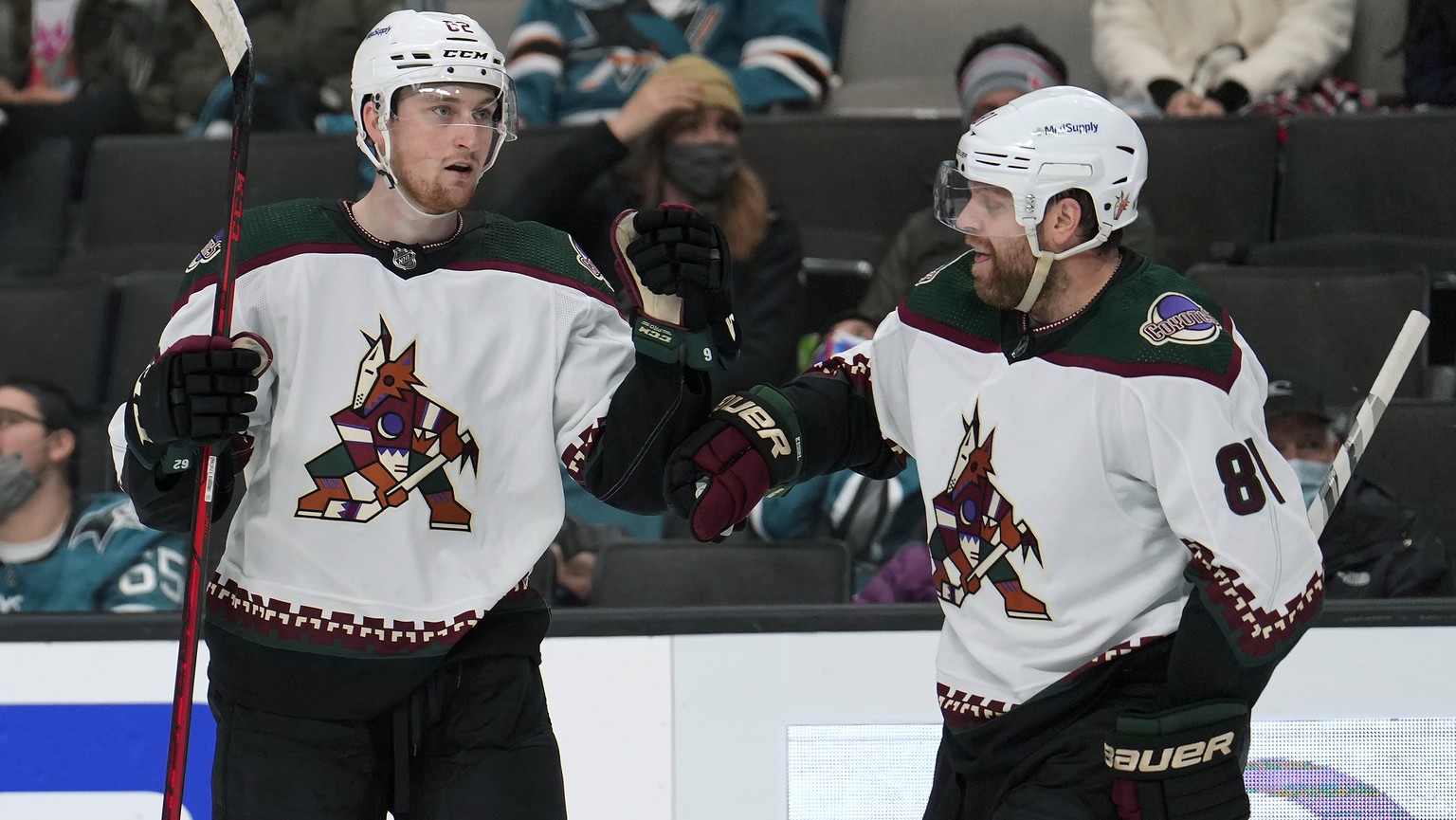 Arizona Coyotes defenseman Janis Moser, left, is congratulated by Phil Kessel (81) after scoring a goal against the San Jose Sharks during the second period of an NHL hockey game Tuesday, Dec. 28, 202 ...