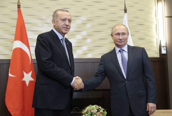 epaselect epa07940189 Russian President Vladimir Putin (R) shakes hands with Turkish President Recep Tayyip Erdogan (L) during their meeting in the Black sea resort of Sochi, Russia, 22 October 2019.  ...