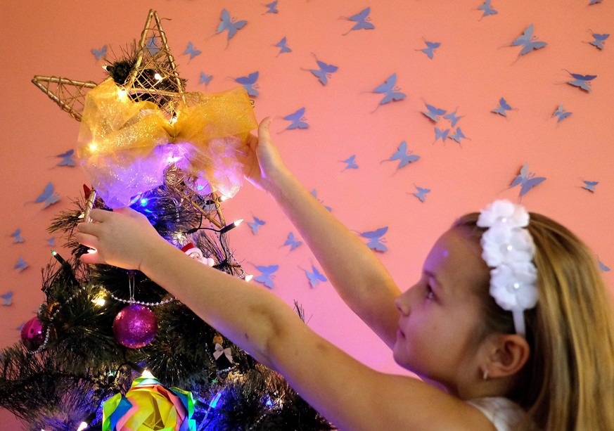 epa05684789 Natalia decorates a Christmas tree at their family house in Przemysl, south-eastern Poland, 21 December 2016. EPA/DAREK DELMANOWICZ POLAND OUT