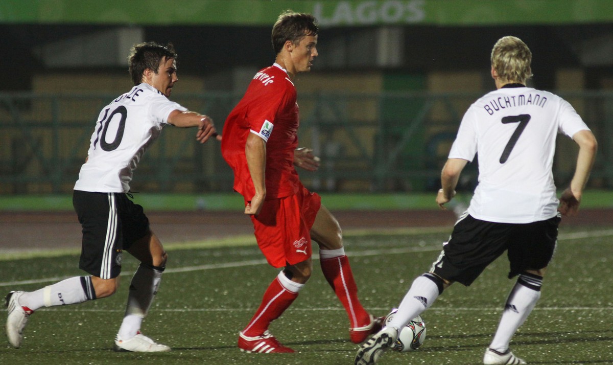 Switzerland's Haris Seferovic, center, is challenged by Germany's Mario Goetze, left, and Christopher Buchtmann during their U17 World Cup round of 16 soccer match in Lagos, Nigeria Wednesda ...