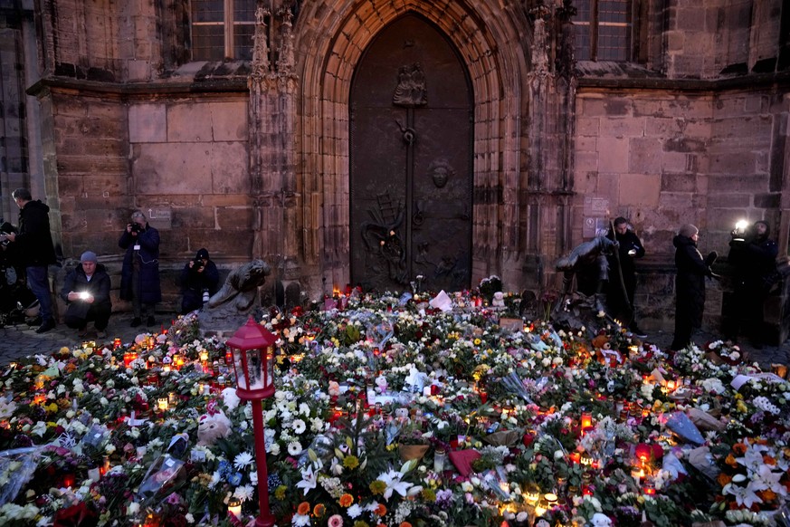 Flowers and candles are placed outside St. John&#039;s Church as a memorial site near a Christmas Market, where a car drove into a crowd on Friday evening, in Magdeburg, Germany, Saturday, Dec. 21, 20 ...