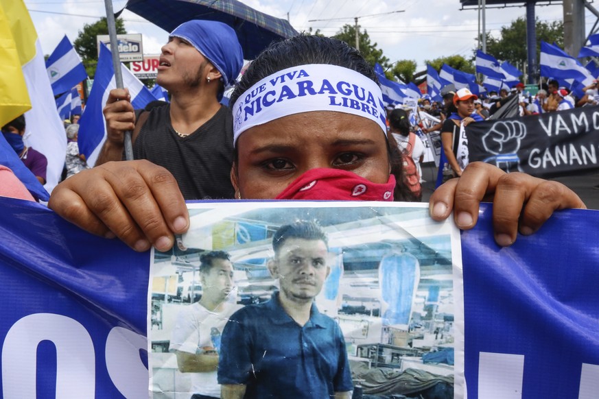 CORRECTS BYLINE - A protestor holds a photo of one of the victims of the deadly protests during an anti-government march in Managua, Nicaragua, Saturday, Aug. 11, 2018. The current unrest began in Apr ...