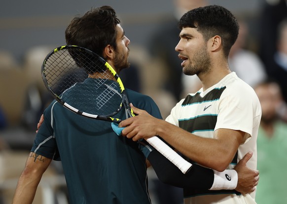 epa12160366 Carlos Alcaraz of Spain (R) hugs with Lorenzo Musetti of Italy after Musetti retired from their Men&#039;s Singles semi-finals match at the French Open Grand Slam tennis tournament at Rola ...