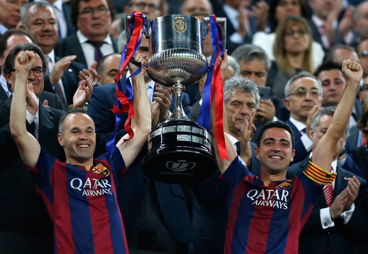 Barcelona's Andres Iniesta, left, and Xavi Hernandez lift the trophy after winning the final of the Copa del Rey soccer match between FC Barcelona and Athletic Bilbao at the Camp Nou stadium in B ...