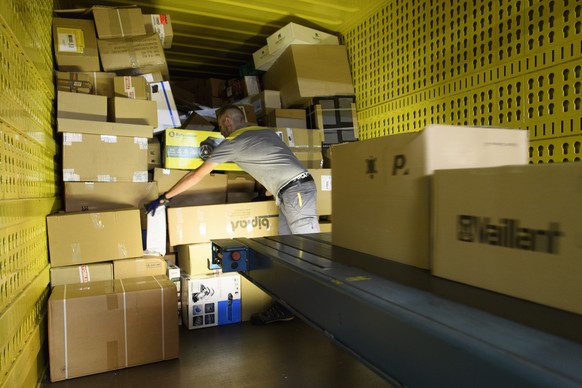 Un employe de la poste suisse decharge des paquets d&#039;un container ce mardi 20 septembre 2016 au centre colis de Daillens, Vaud. La Poste a equipe le centre colis de Daillens d&#039;une installati ...