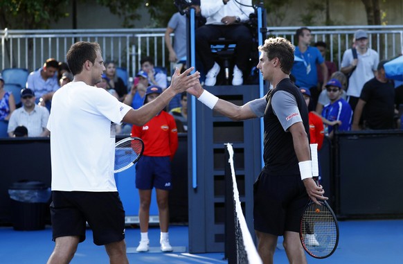 epa07282103 Henri Laaksonen (R) of Switzerland is congratulated by Mirza Basic (L) of Bosnia and Herzegovina after winning their men&#039;s singles first round match of the Australian Open Grand Slam  ...