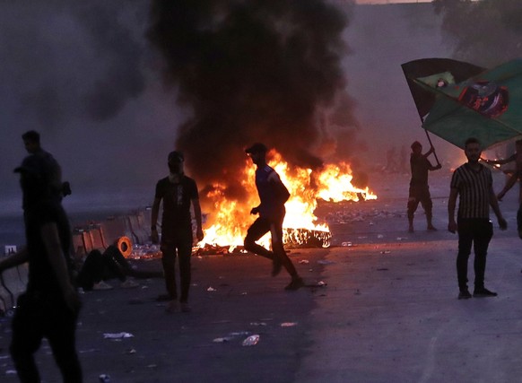 Anti-government protesters set fires and close a street during a demonstration in Baghdad, Iraq, Friday, Oct. 4, 2019. Security forces opened fire directly at hundreds of anti-government demonstrators ...
