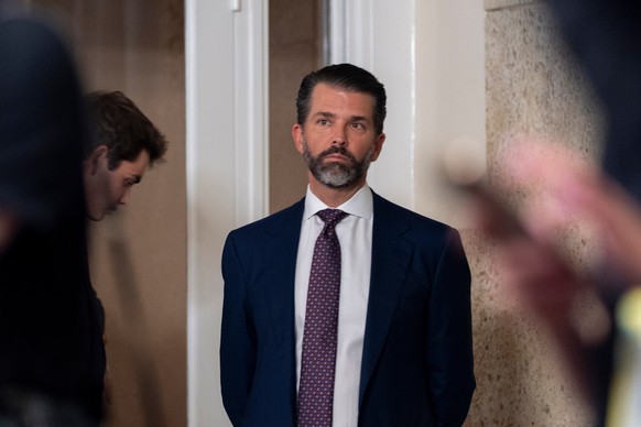 Donald Trump Jr., listens as his father President Donald Trump speaks to troops via video from his Mar-a-Lago estate on Thanksgiving, Thursday, Nov. 27, 2025, in Palm Beach, Fla. (AP Photo/Alex Brando ...