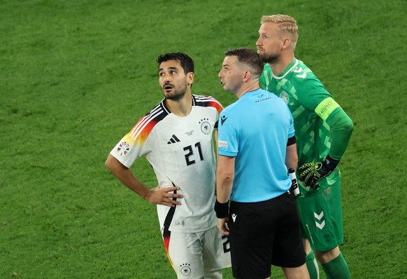epa11446160 .English referee Michael Oliver chats with Ilkay Guendogan (L) of Germany and goalkeeper Kasper Schmeichel (R) of Denmark prior to the second half of the UEFA EURO 2024 Round of 16 soccer  ...