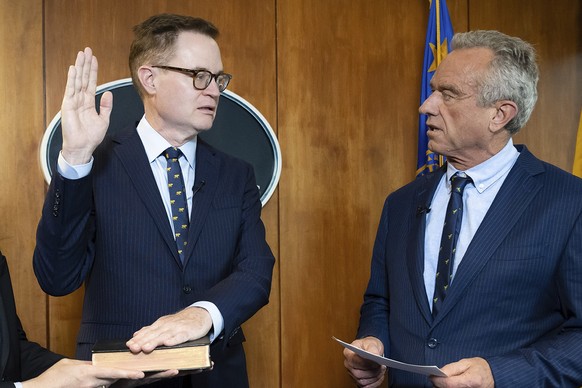 In this photo provided by the Department of Health and Human Secretary, Robert F. Kennedy, Jr., right, conducts the swearing-in ceremony of Jim O&#039;Neill as the Department&#039;s Deputy Secretary,  ...