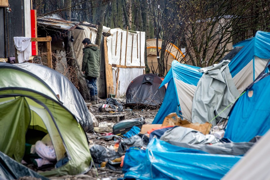 epaselect epa05095652 A refugee walks through the refugee camp in the coastal town of Grande-Synthe near Dunkirk, northern France, 10 January 2016. Despite most of the attention is on the so-called &# ...