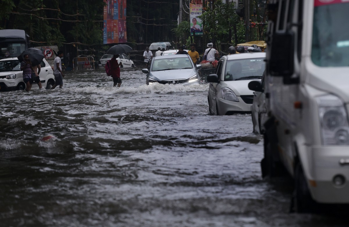 epa12399417 Vehicles drive through a waterlogged street after heavy showers in the eastern Indian city of Kolkata, 23 September 2025. The India Meteorological Department (IMD) issued a yellow alert fo ...