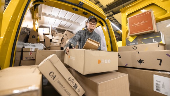 Der Paketbote der Schweizerischen Post Carlos Hugo Vega sortiert Pakete beim Beladen der Lieferwagen fuer die Zustellung, in der Distributionsbasis Oerlikon, aufgenommen am Dienstag, 5. Dezember 2023  ...