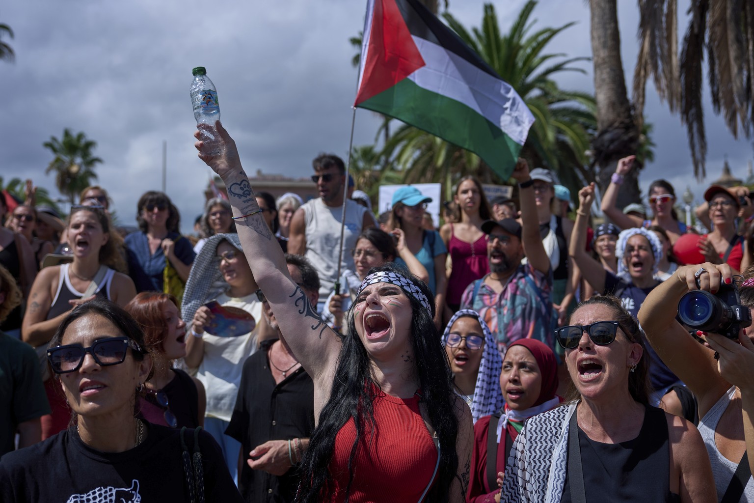 People shout slogans as they bid farewell to activists setting sail on their boats to join a civilian flotilla bound for Gaza, with the aim of breaking the Israeli blockade and delivering humanitarian ...