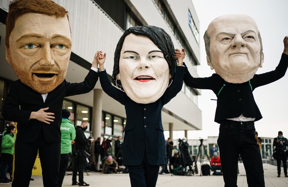 epaselect epa09518123 Activists of Campact wearing masks resembling (L-R) Free Democratic Party (FDP) chairman and faction chairman in the German parliament Bundestag Christian Lindner, Green party (D ...