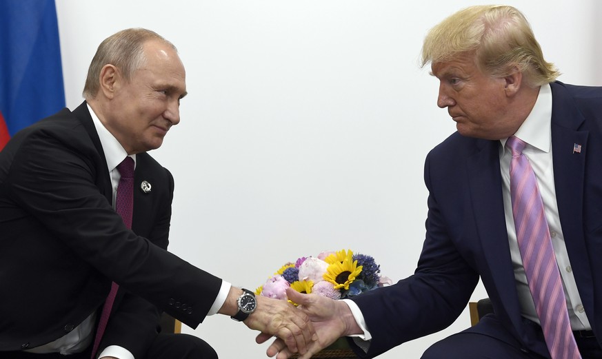 FILE - In this June 28, 2019, file photo, President Donald Trump, right, shakes hands with Russian President Vladimir Putin, left, during a bilateral meeting on the sidelines of the G-20 summit in Osa ...