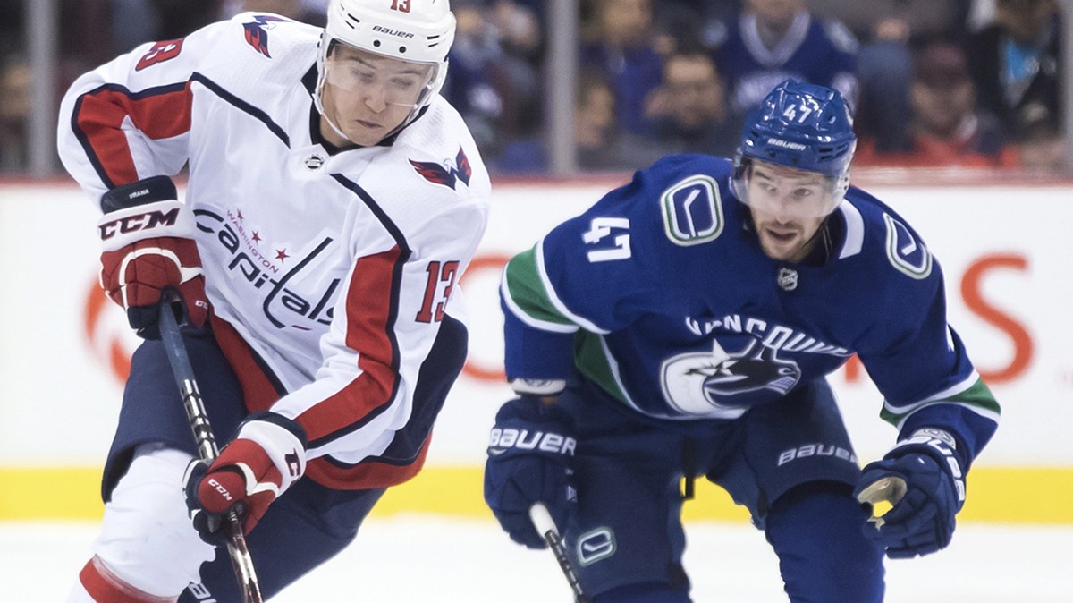 Washington Capitals' Jakub Vrana, front left, of the Czech Republic, skates with the puck while being watched by Vancouver Canucks' Sven Baertschi, of Switzerland, during the first period of ...