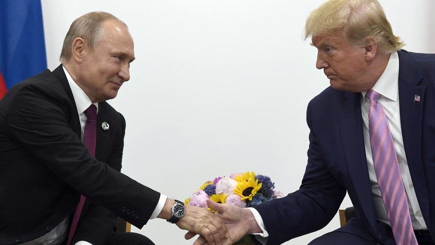FILE - In this June 28, 2019, file photo, President Donald Trump, right, shakes hands with Russian President Vladimir Putin, left, during a bilateral meeting on the sidelines of the G-20 summit in Osa ...