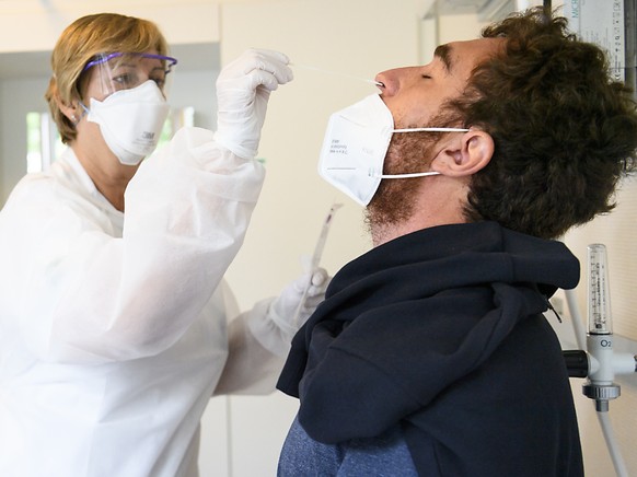 Eine Gesundheitsmitarbeiterin macht einen Nasenabstrich, um den Patienten auf Sars-CoV-2 zu testen. (Archivbild)