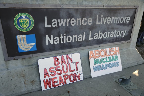 epa12287465 Anti-nuclear weapons signs at the entrance to the West Gate of the Lawrence Livermore National Laboratory (LLNL), known for its work in nuclear weapons design, stockpile stewardship, and n ...