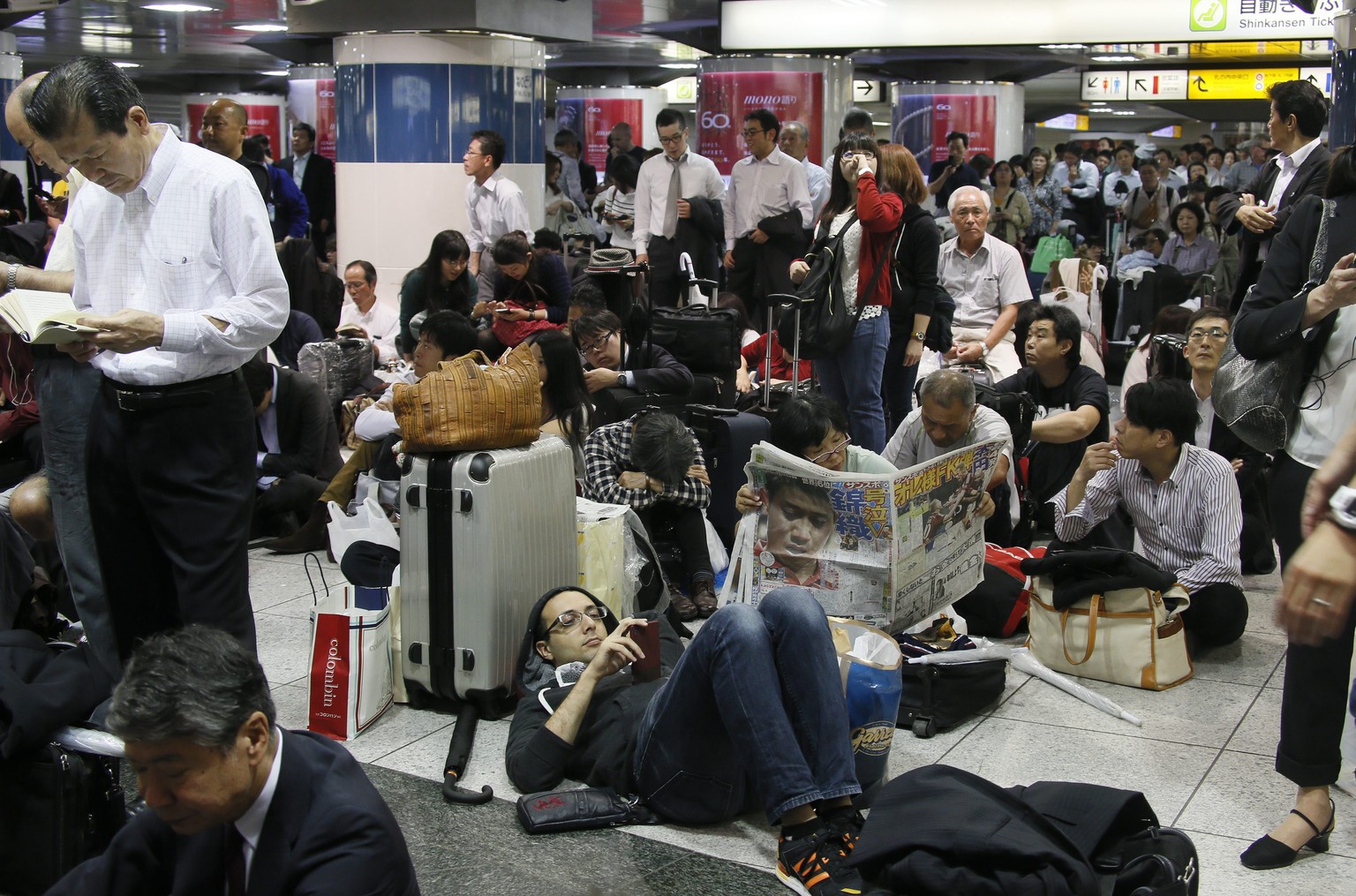 Japans Hochgeschwindigkeitszug Shinkansen fiel aufgrund des Taifuns mehrere Stunden aus – Passagiere in einer Wartehalle in Tokio.