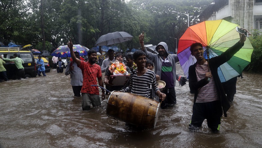 People carrying a Hindu god Ganesha idol for immersion in the Arabian Sea walk through a waterlogged street following heavy rains in Mumbai, India, Tuesday, Aug. 29, 2017. Heavy rains Tuesday brought  ...