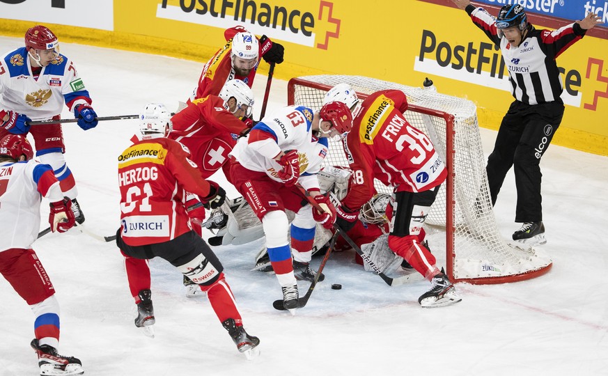 Russia&#039;s and Switzerland&#039;s players fight for the puck in front of Switzerland&#039;s goalkeeper Niklas Schlegel during a friendly ice hockey match between Switzerland and Russia, at the Tiss ...
