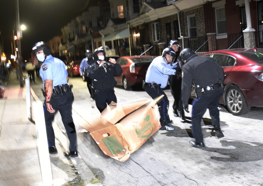 Debris is thrown at police during a demonstration Tuesday night, Oct. 27, 2020, in Philadelphia. Hundreds of demonstrators marched in West Philadelphia over the death of Walter Wallace Jr., a Black ma ...