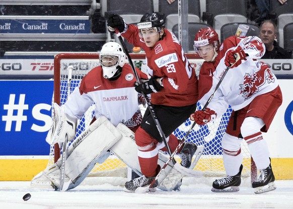 Switzerland forward Timo Meier, center, fights for the puck between Denmark goaltender Georg Sorensen, left, and defenseman Mads Larsen during the first period of a round-robin game at the hockey Worl ...