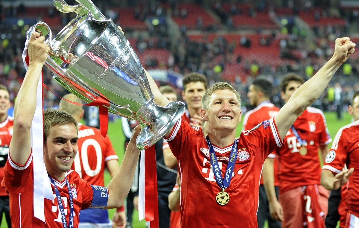 epa03717490 Bayern Munich's Philipp Lahm (L) and Bastian Schweinsteiger (R) celebrate with the trophy after the UEFA Champions League final between Borussia Dortmund and Bayern Munich at Wembley  ...
