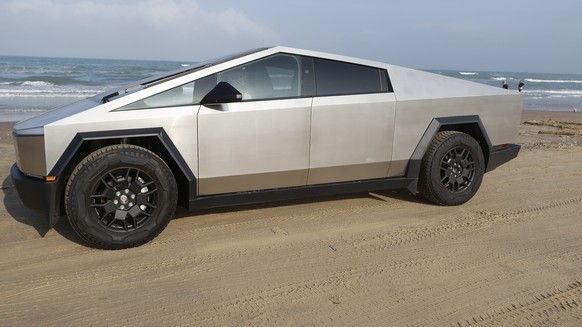 epa11219407 A Tesla Cybertruck is parked on the beach near the mega rocket Starship, which wis put in position before a test launch as SpaceX gets ready for their upcoming launch at Starbase in Boca C ...