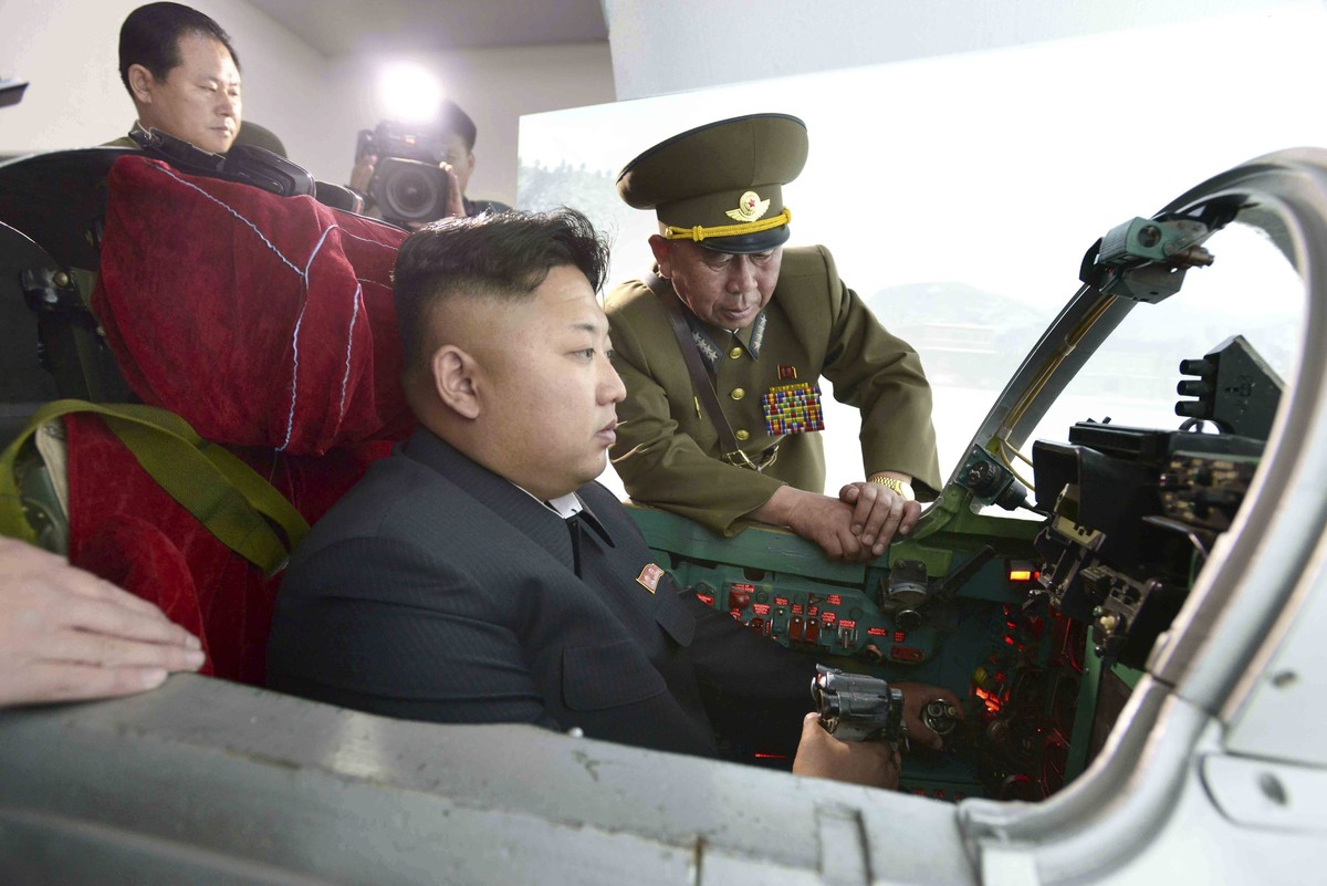 epa04206223 An undated picture made available by the North Korean Central News Agency (KCNA) on 15 May 2014 shows North Korean leader Kim Jong-un (C) learning to fly an airplane at the North Korean Ai ...
