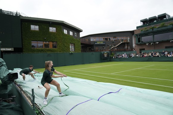 The rain covers are removed from the courts after a rain delay on day one of the Wimbledon Tennis Championships in London, Monday June 28, 2021. (AP Photo/Alberto Pezzali)