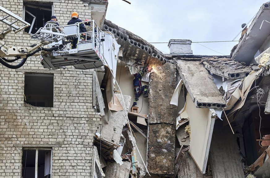 epa10065464 Rescuers clean debris of a damaged residential building following a Russian rocket strike hitting the city of Kharkiv, Ukraine, 11 July 2022. At least six people were killed and 31 injured ...