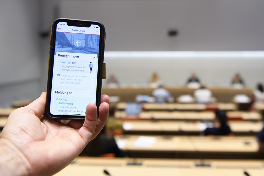 Eine Person nutzt die SwissCovid Contact Tracing App auf ihrem Smartphone, fotografiert waehrend einer Medienkonferenz ueber das referendum STOP SwissCovid ! von Referendumgskomitee gegen die Covid19- ...