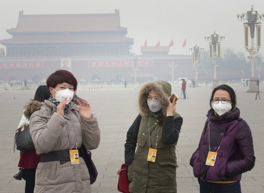 epa04107712 Chinese journalists wearing face masks to protect themselves from thick smog await the arrival of delegates prior to the opening session of the second plenum of the 12th National Committee ...