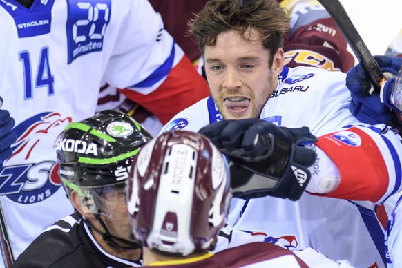 Le joueur zurichois, David Rundblad, droite, a la lutte avec le joueur Genevois, Tim Traber, gauche, lors du match du championnat suisse de hockey sur glace de National League LNA, entre le Geneve Ser ...