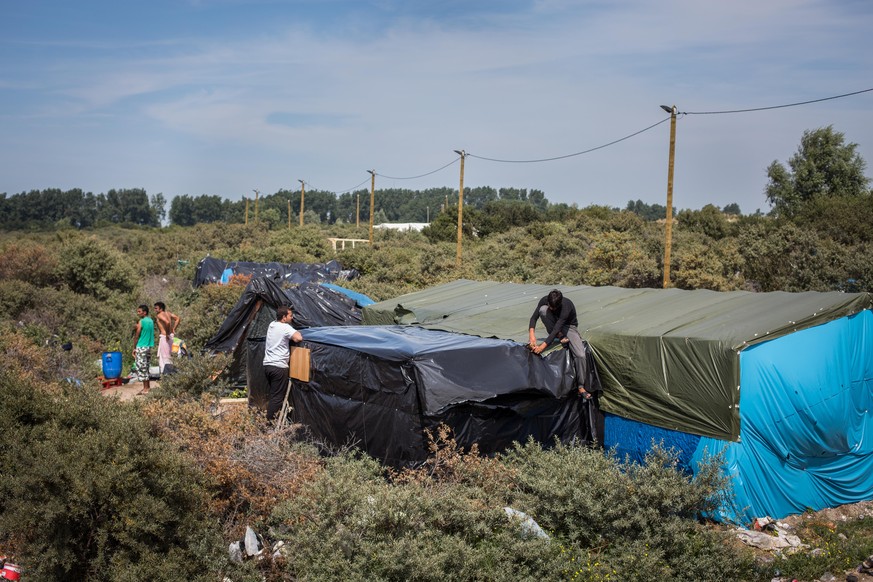 Männer arbeiten an einem Zelt im provisorischen Flüchtlingslager in Calais.