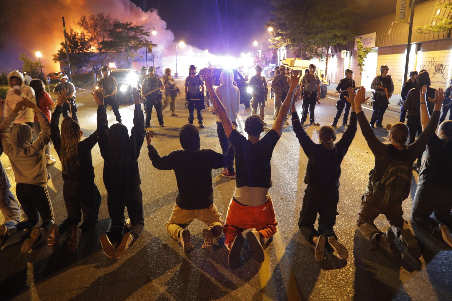 Demonstrators kneel before police Saturday, May 30, 2020, in Minneapolis. Protests continued following the death of George Floyd, who died after being restrained by Minneapolis police officers on Memo ...